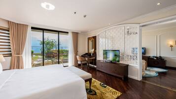 Habitación de hotel con una cama grande, un escritorio, televisión y vistas al exterior.