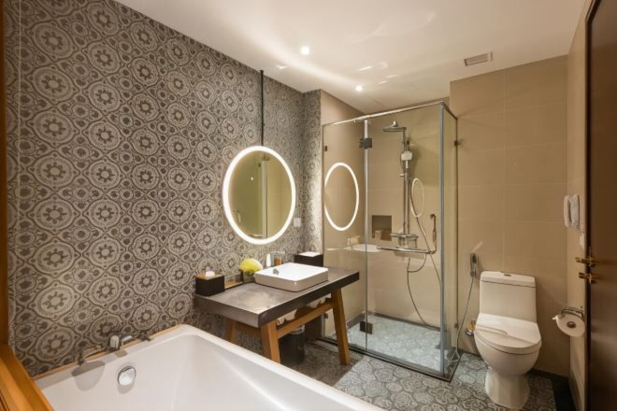 A modern bathroom with a freestanding bathtub, a vanity with a mirror, and a shower enclosure.