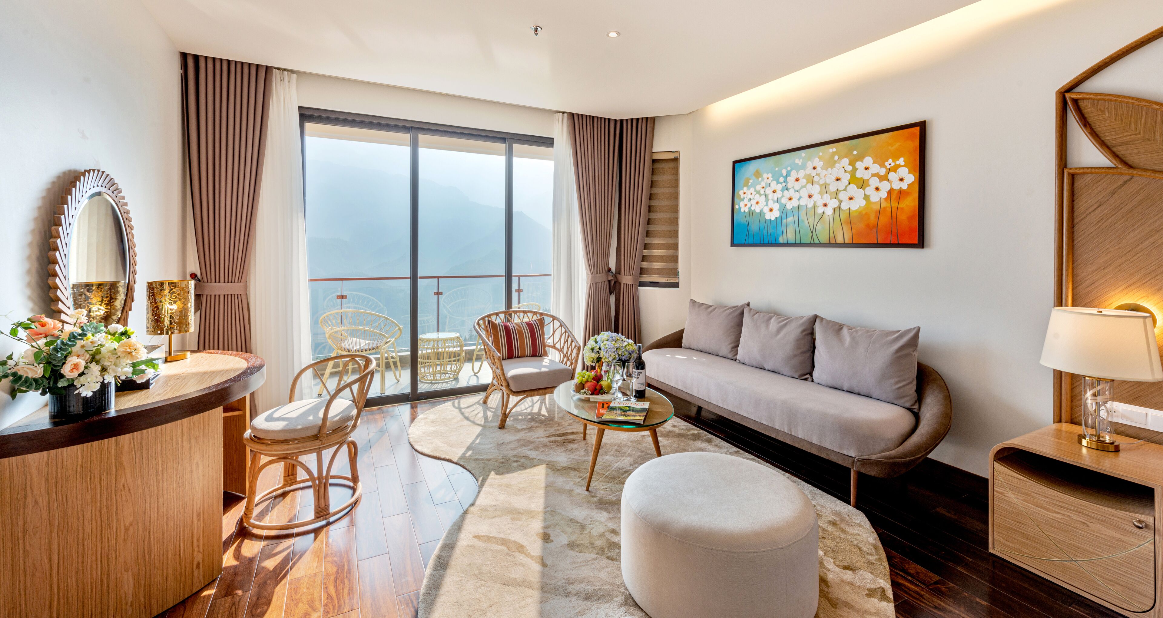 Une chambre d’hôtel moderne dotée d’un balcon, d’un canapé, d’un coin repas et d’un tableau au mur.