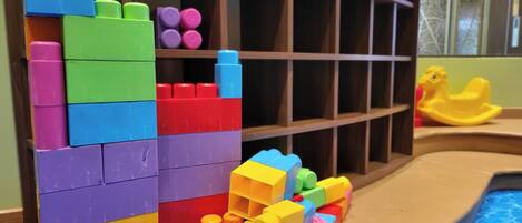 A pool area with colorful building blocks and a yellow rubber duck.