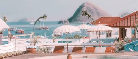 Piscine extérieure, parasols de plage, chaises longues
