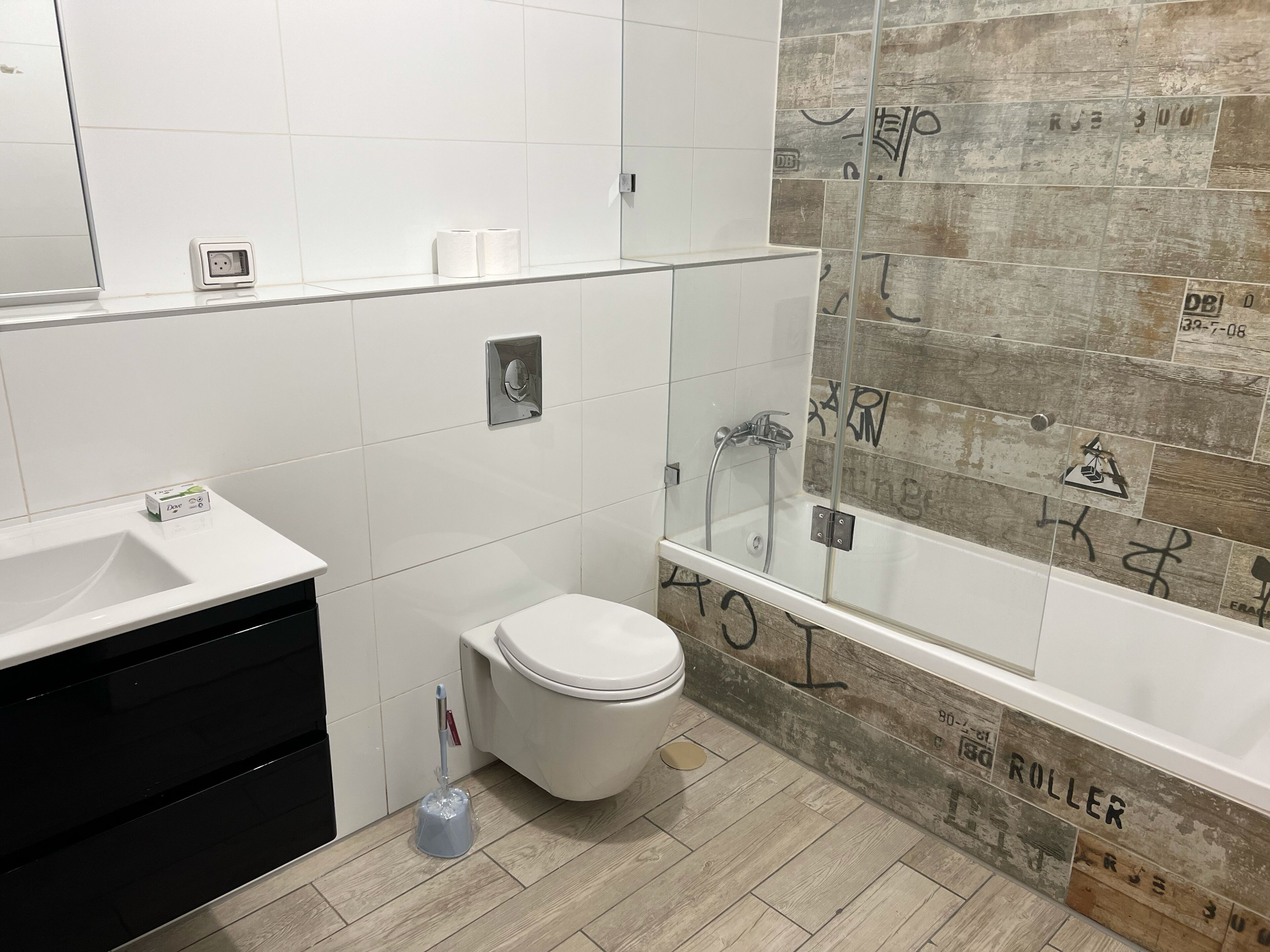 Un baño moderno con inodoro, lavabo y zona de ducha.