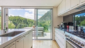 Een moderne keuken met een groot raam, een fornuis en een spoelbak.