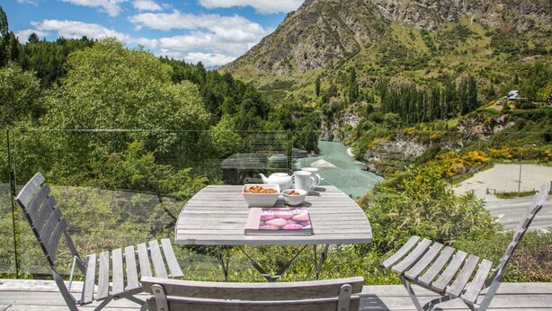 Een tafel met uitzicht op een rivier en bergen.