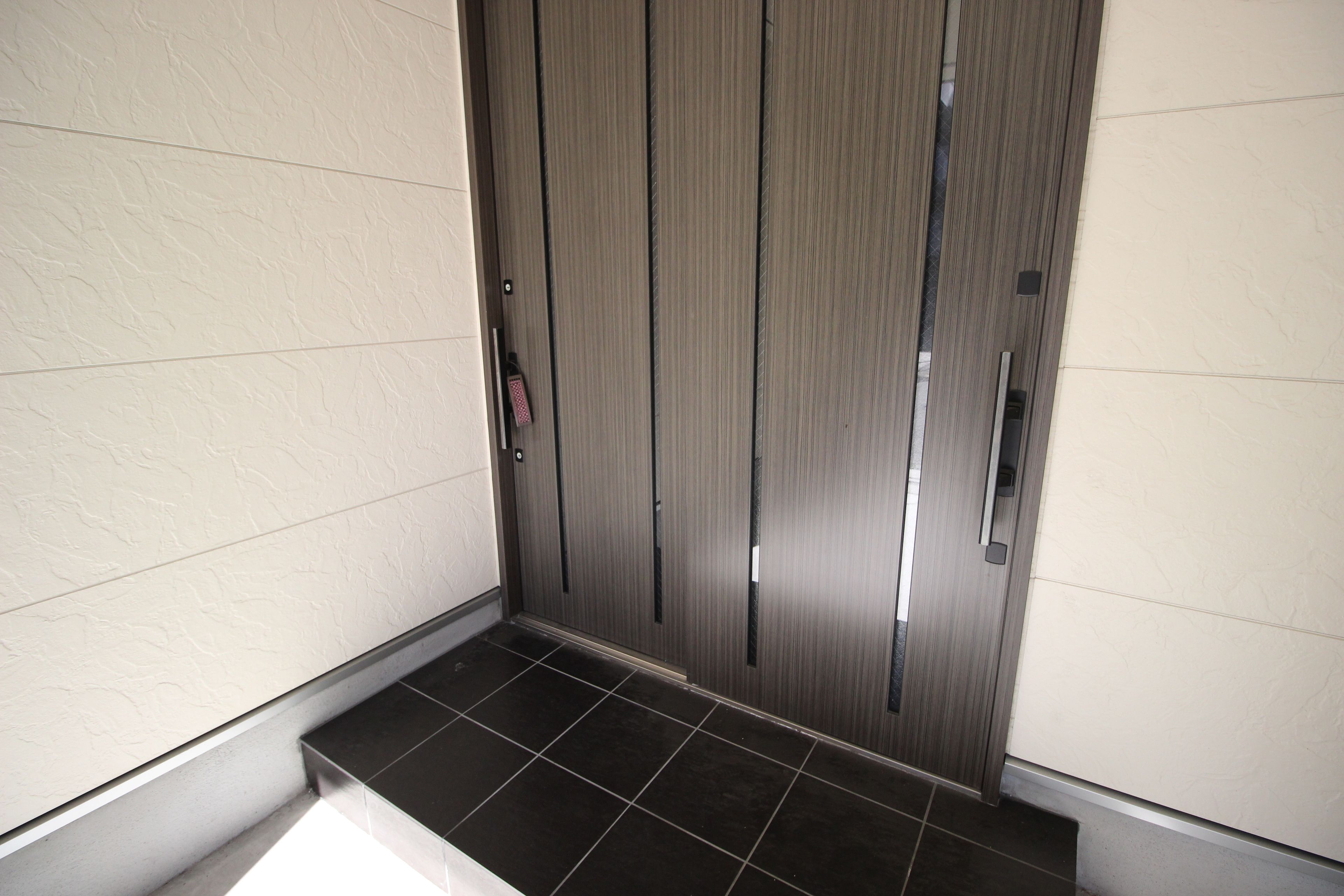 A modern elevator with a metallic finish and a control panel on the left.
