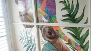 A room with a white wall featuring colorful animal and plant murals. - Fan Zai Cuo (Liuqiu)