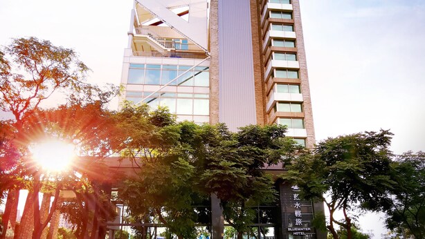 Un hôtel moderne doté d’une architecture originale, caractérisé par une tour verticale imposante et une structure de toit inclinée.