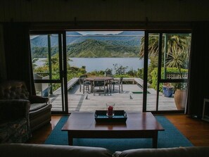 Una habitación con un amplio ventanal corredera que da a una terraza exterior con una mesa y sillas.