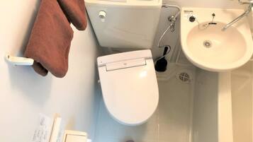 A bathroom with a toilet, sink, and bathtub.