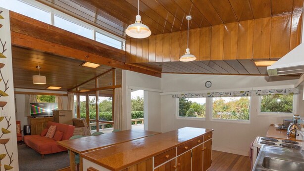 Une cuisine moderne avec des meubles en bois, un évier en acier inoxydable et un grand îlot central.