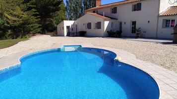 Una piscina al aire libre de temporada, sombrillas