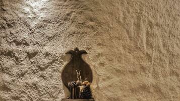 A textured wall with a wall-mounted light fixture and a decorative object.