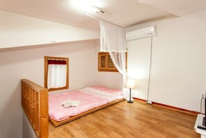 A single bedroom with a wooden bed, a bedside table, a lamp, and a window with curtains. - Jirisan Shiri Pension (Gurye)