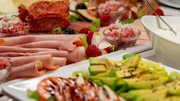 A variety of food items including meats, fruits, and dips.