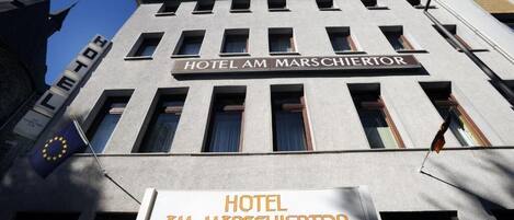 El exterior del Hotel Am Marschiertor, con una vista clara de su fachada, incluyendo la señalización del nombre y la bandera de la Unión Europea.