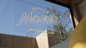 Un cartel con el nombre 'Sopela Moana' y 'ecosurfhouse' escrito.