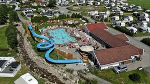 Un espace de loisirs comprenant une piscine, des toboggans aquatiques et des chaises longues.