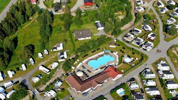 Residents can enjoy a central swimming pool surrounded by sun loungers and umbrellas.