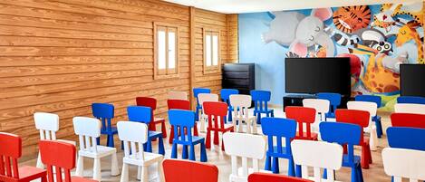 A room with wooden walls, a large mural, and rows of colorful chairs.