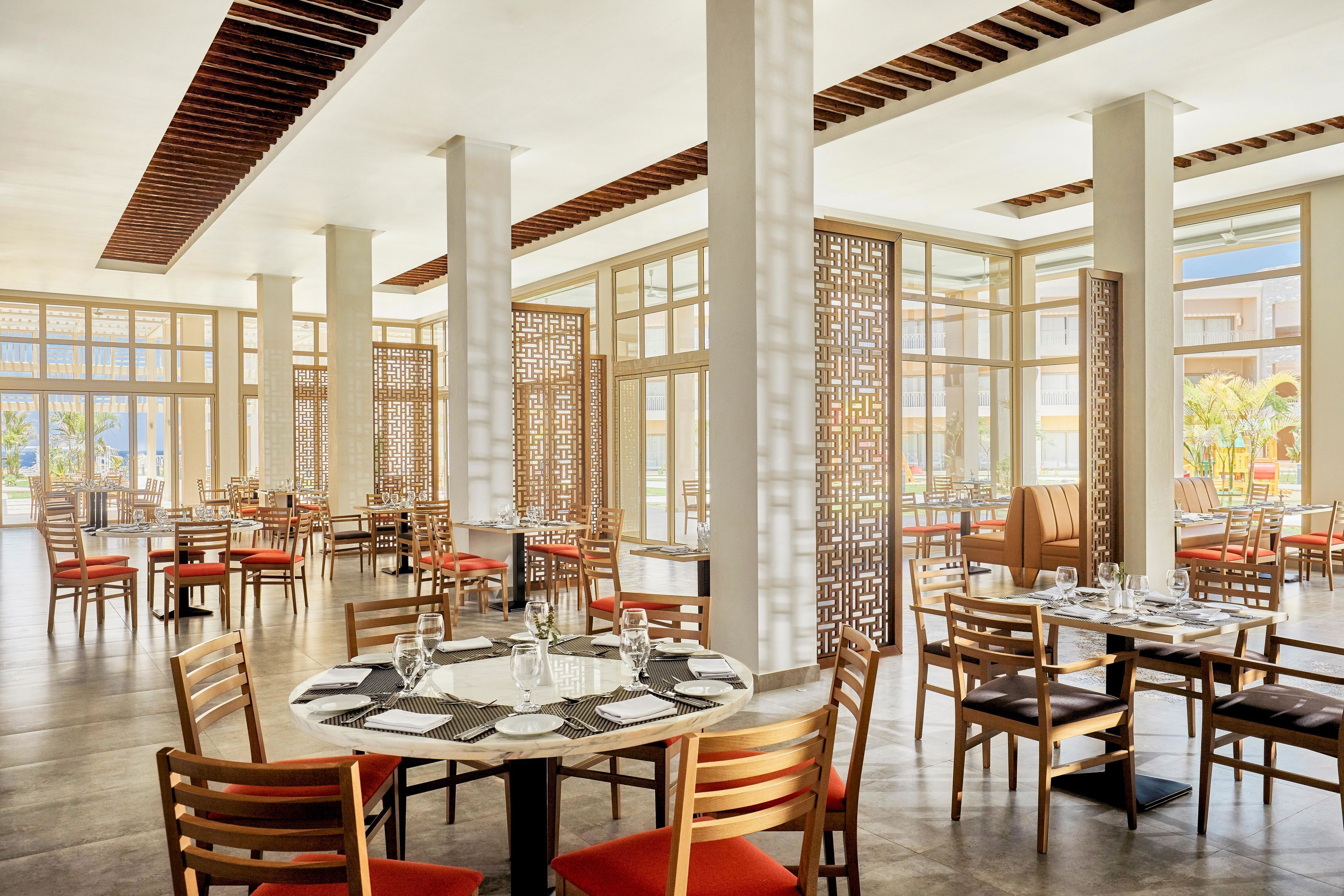 Un comedor espacioso con techos altos, ventanas grandes y un diseño interior moderno.