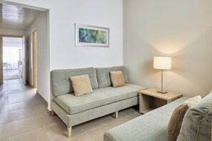 A modern living room with a sofa, a side table, and a lamp. - JAZ Elite Maraya - All inclusive (El Quseir)