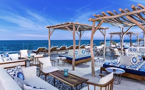 A seaside lounge with outdoor seating, a pergola structure, and a view of the ocean. - JAZ Elite Maraya - All inclusive (El Quseir)