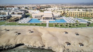 Een resort met een centraal zwembad, meerdere gebouwen en een woestijnlandschap.