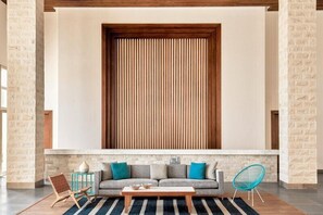 Uma sala de estar moderna com um sofá, uma mesa de centro e duas poltronas.