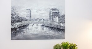 Une peinture en noir et blanc représentant un pont enjambant une étendue d’eau, entouré d’immeubles.