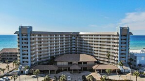 A large hotel with multiple floors, a central courtyard, and a view of the ocean. - Beach Front Condo PCB! Spring/Fall and Winter Discount Rates Available Now!! (Panama City Beach)