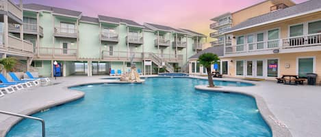 Une piscine entourée d’immeubles à plusieurs étages, dotés de balcons et d’espaces de détente en plein air.
