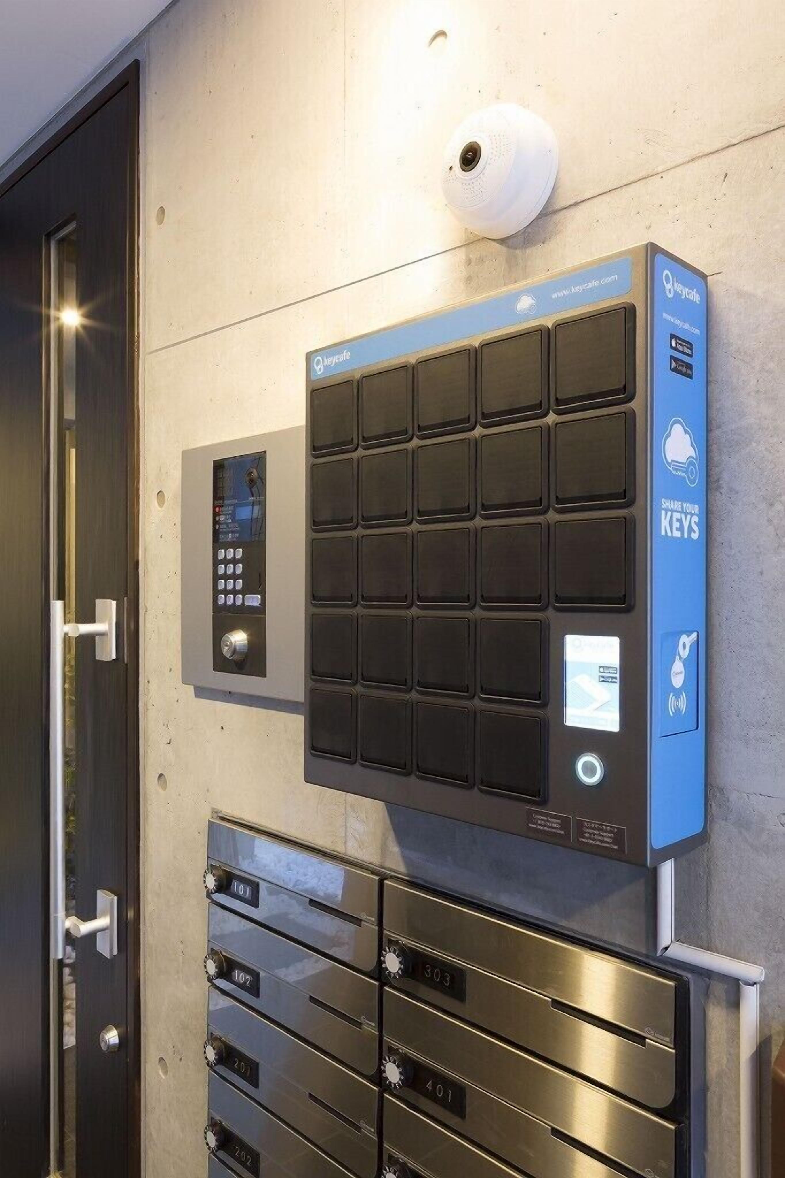 A modern elevator with a keypad and a digital display, a wall-mounted keycard reader, and a set of numbered key slots.