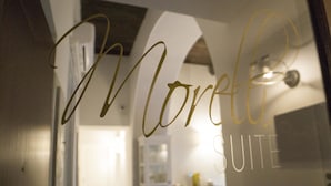 En glasdør med teksten "Morelli Suite", som angiver navnet på hotelværelset.