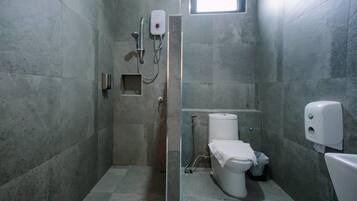 Baño con ducha, inodoro y secamanos.
