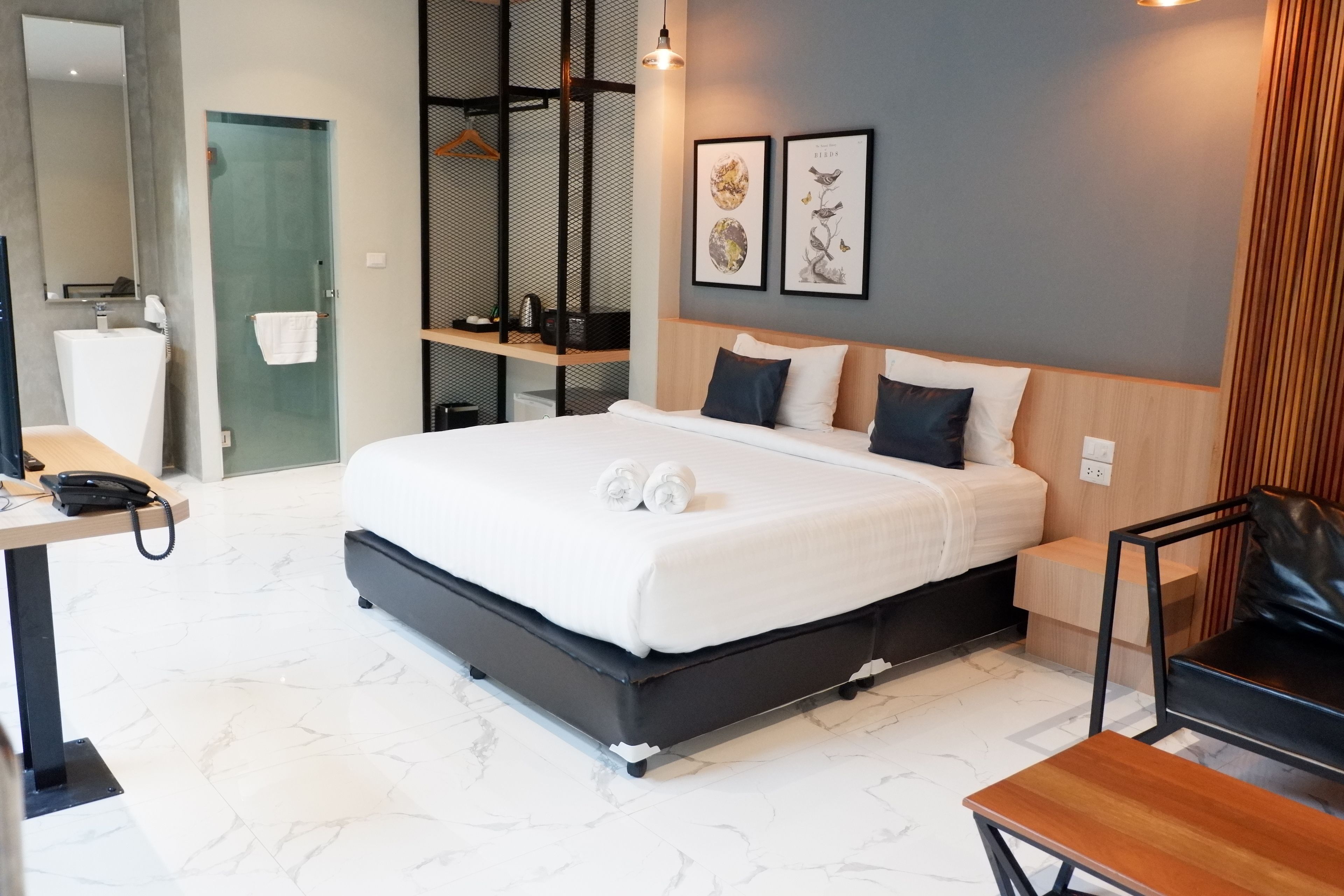 Une chambre d’hôtel moderne avec un grand lit, un bureau, une chaise et une petite table.