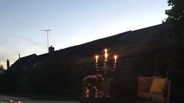 Una piscina con un muro de piedra y un candelabro.