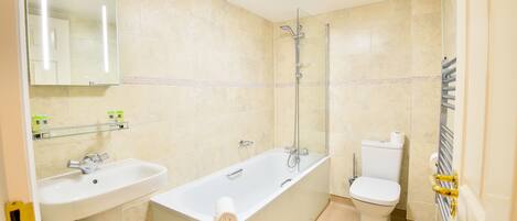 A bathroom with a bathtub, sink, toilet, and a glass shower enclosure.