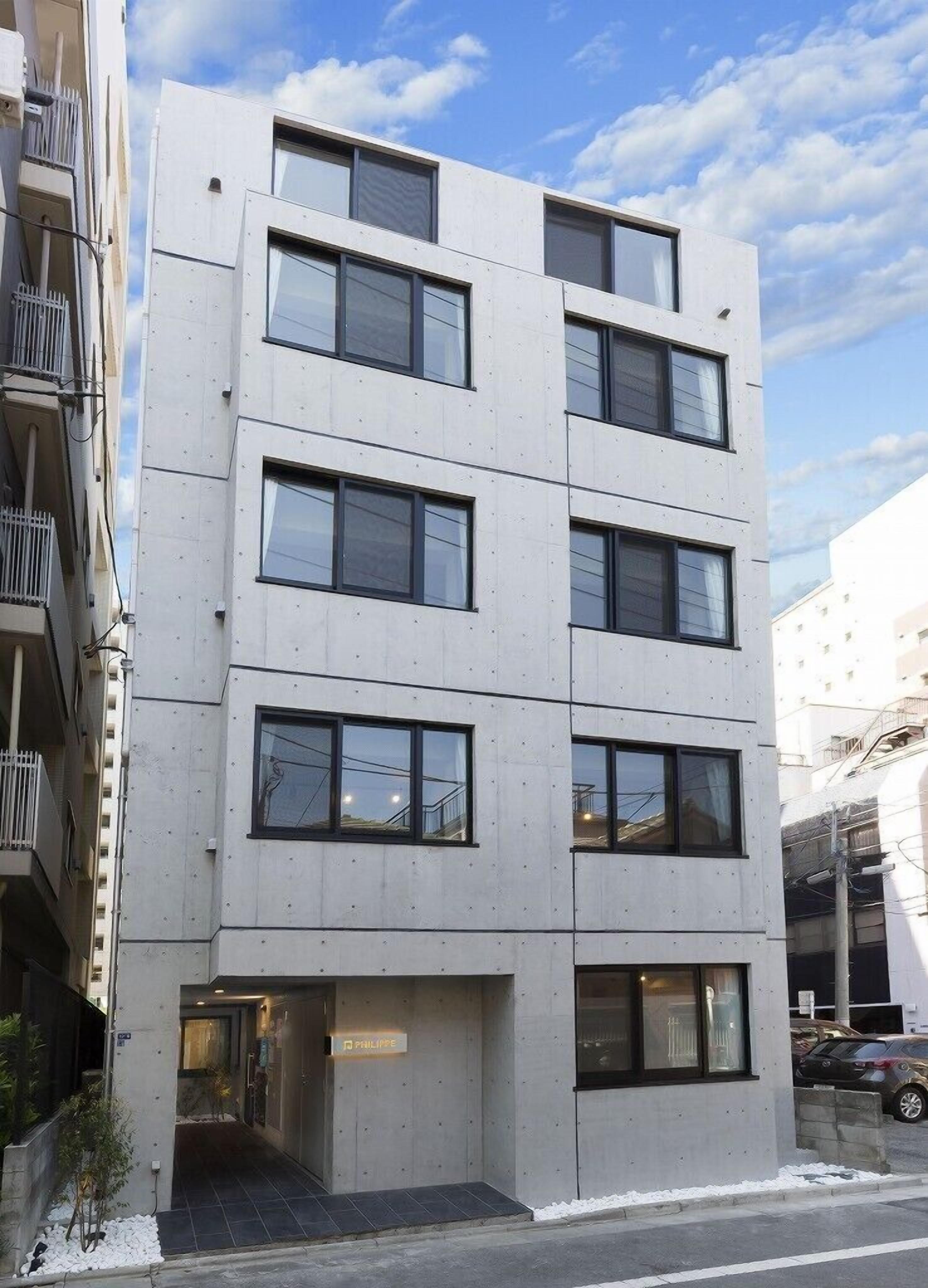 A multi-story building with a flat facade, large windows, and a visible entrance.