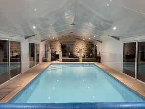 Innendørsbasseng,et oppvarmet basseng, bassengparasoller og solsenger