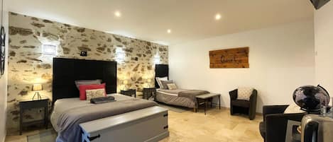 A modern bedroom with a large bed, bedside tables, a desk, and a chair.
