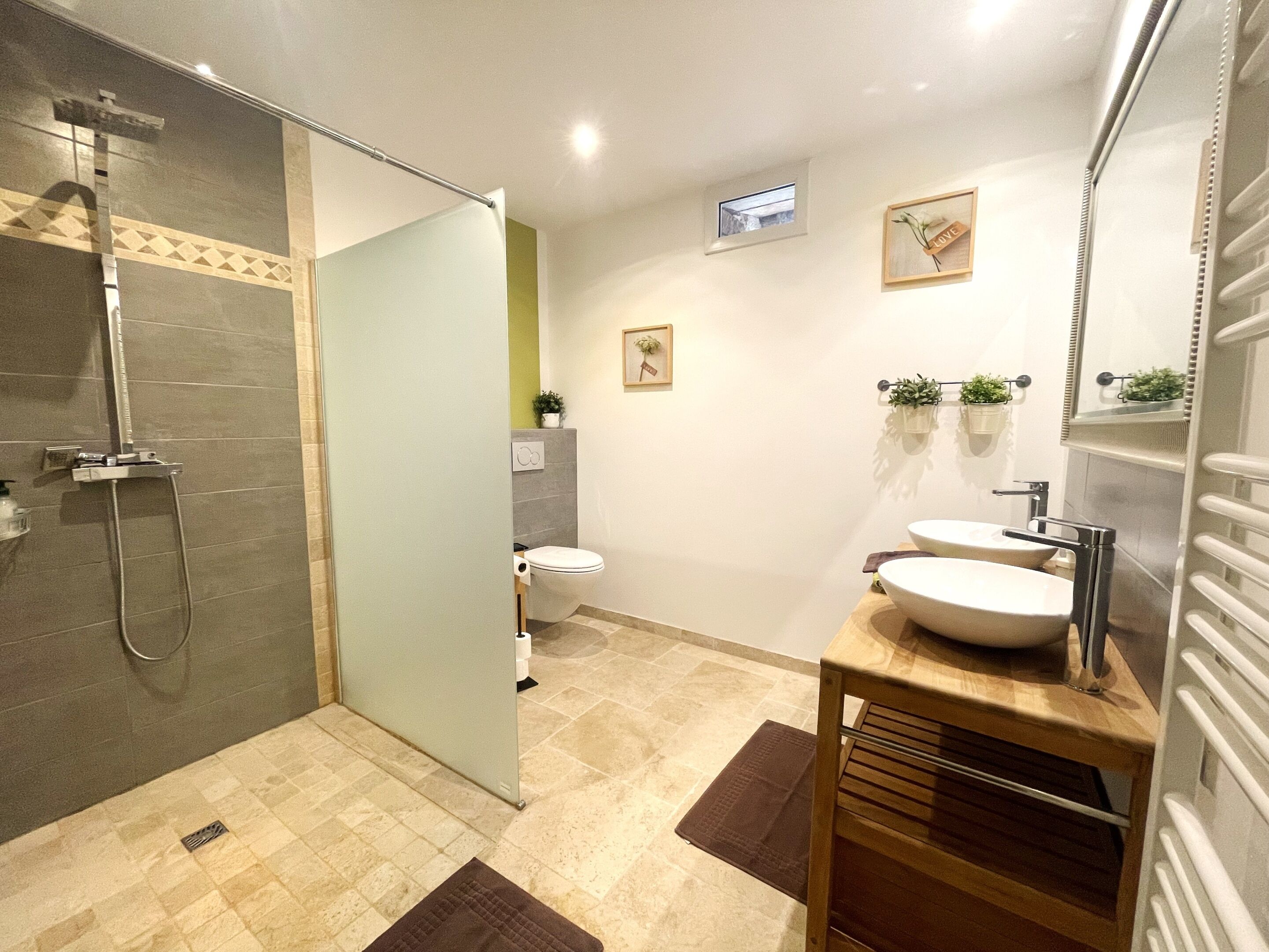 Une salle de bain moderne équipée d’une douche, de toilettes et d’un lavabo.