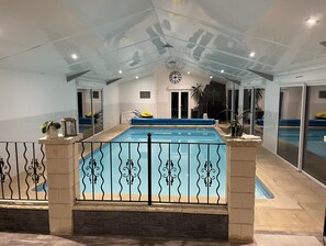 Alberca techada, alberca climatizada y sombrillas en la alberca