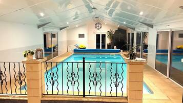 Piscine couverte, piscine chauffée, parasols de plage, chaises longues