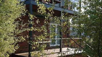 A modern two-story building with a balcony and a brick facade.