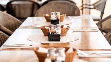 A dining table set with salt and pepper shakers, a placemat, and a menu.