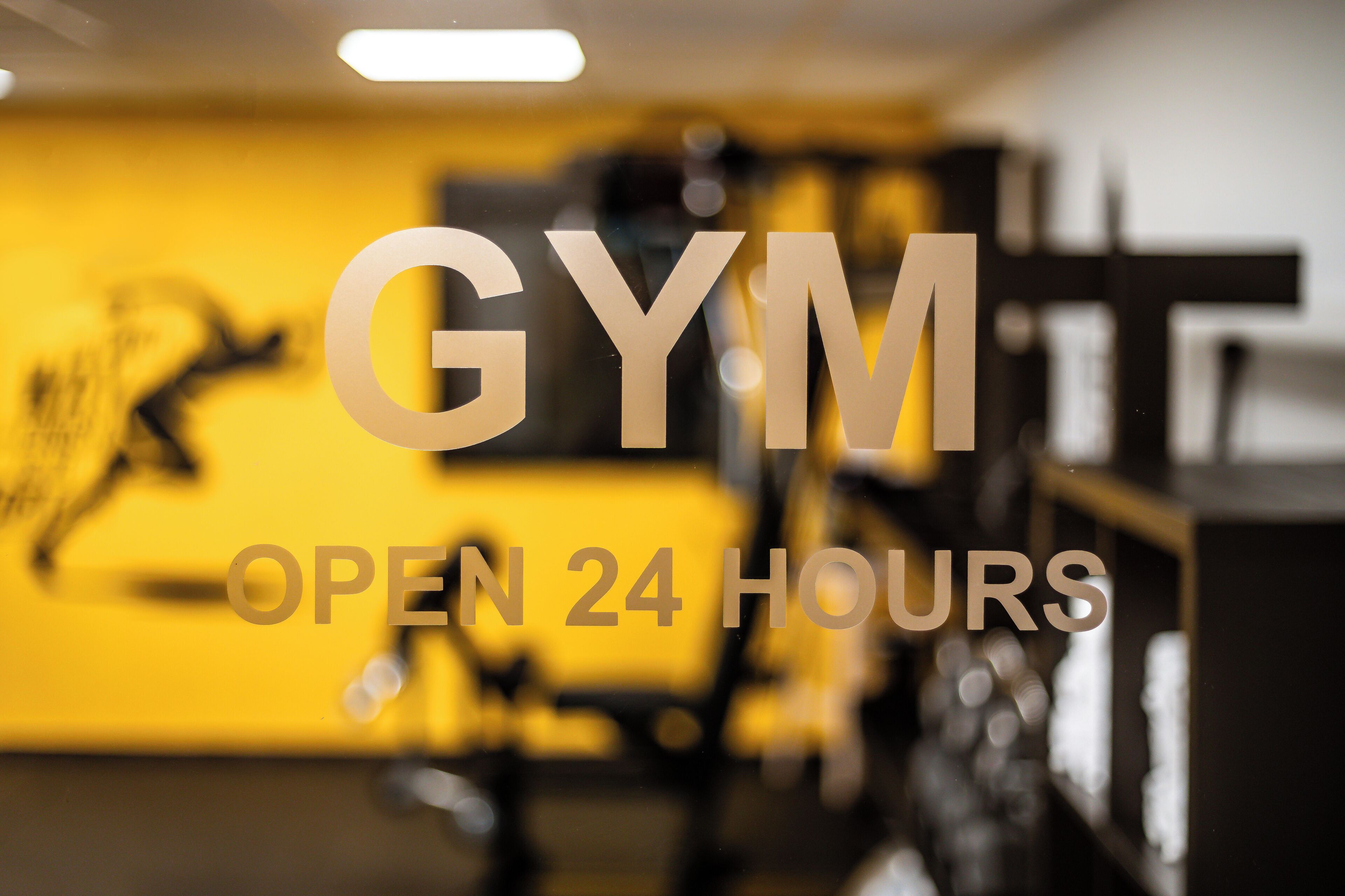 A gym with a sign indicating it is open 24 hours.
