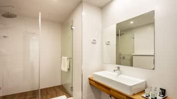 A modern bathroom with a glass-enclosed shower, a white sink, and a wooden vanity.