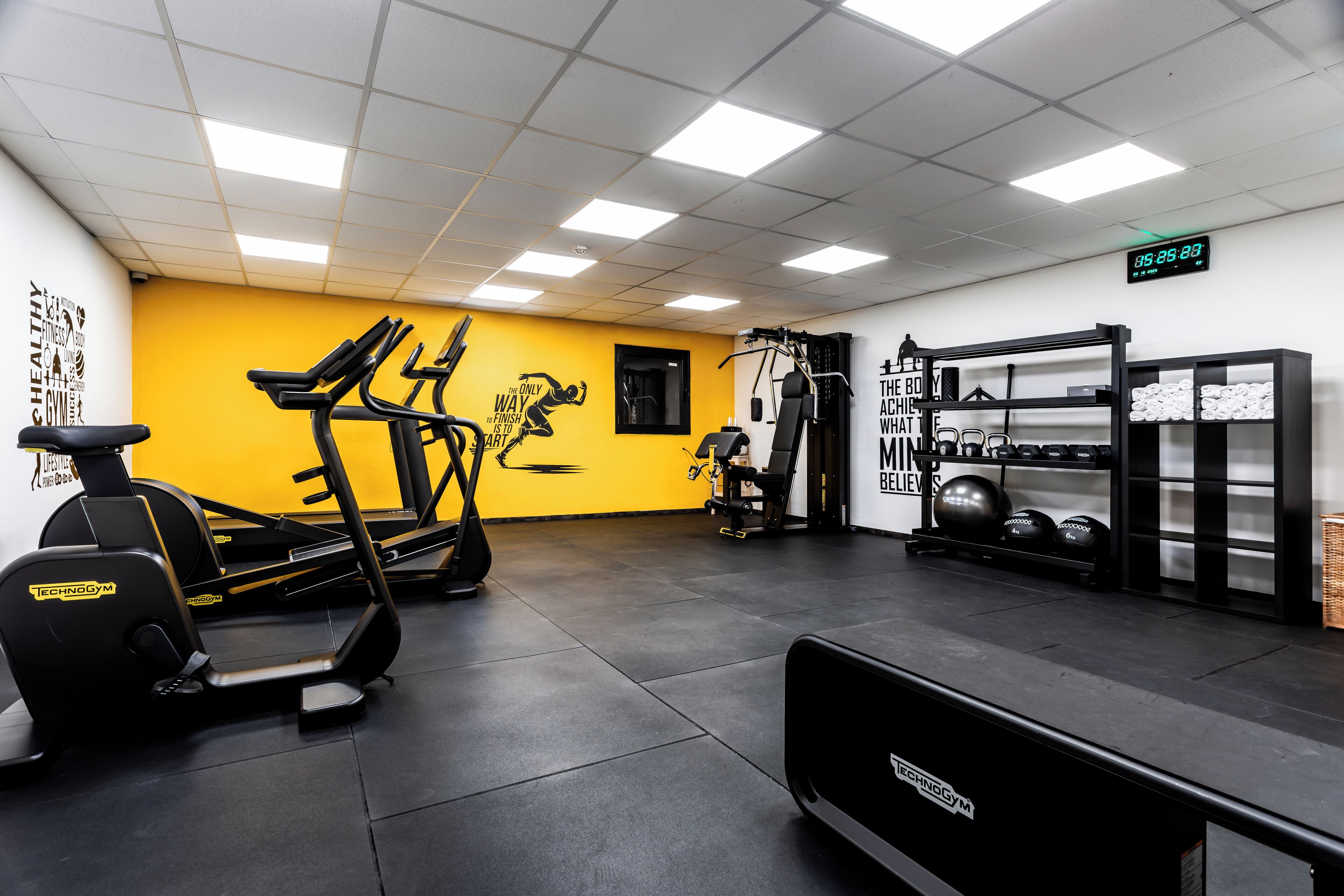 A gym with treadmills, a stationary bike, and weightlifting equipment.
