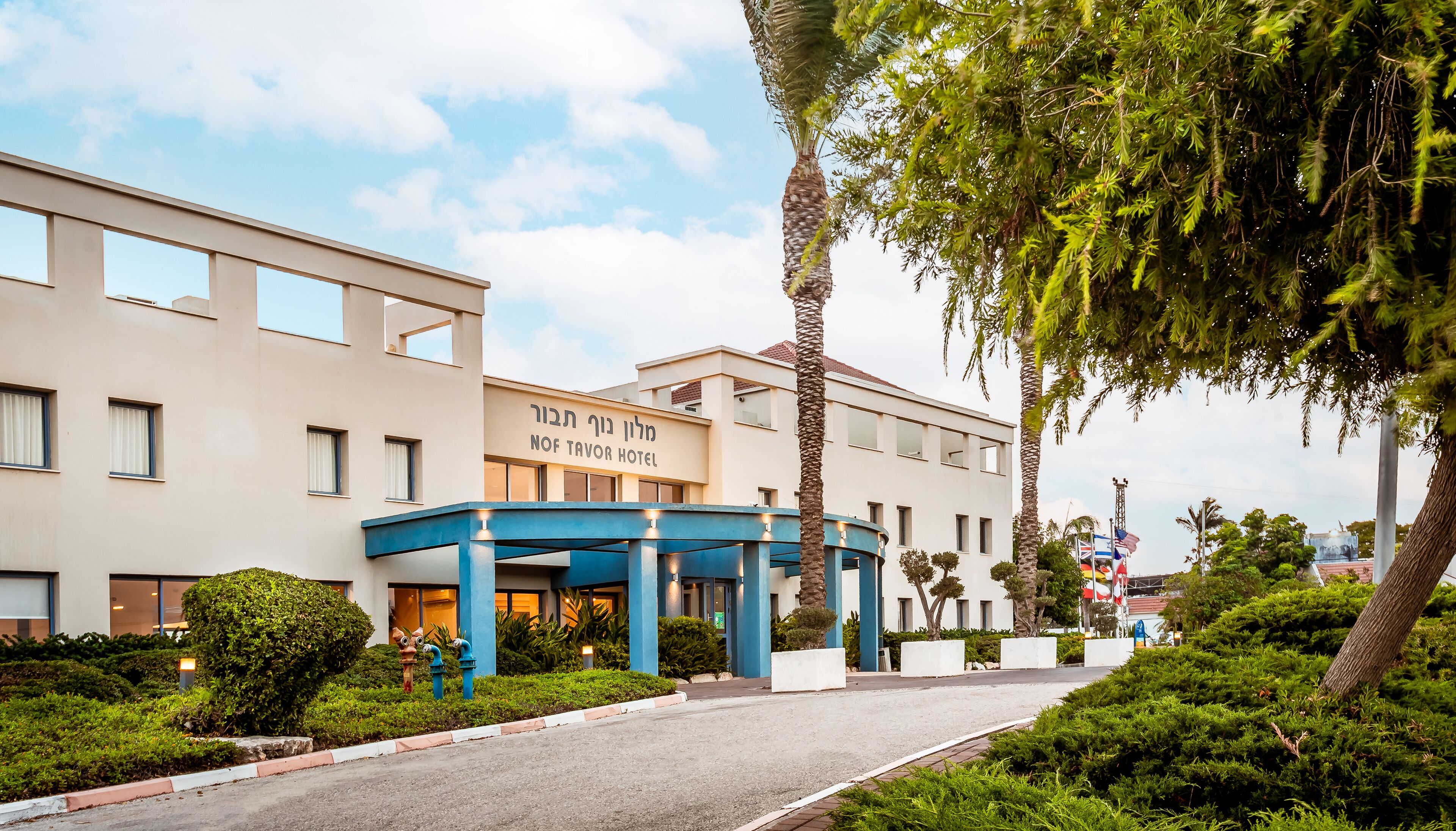 A hotel with a modern facade, a covered entrance, and well-maintained landscaping.