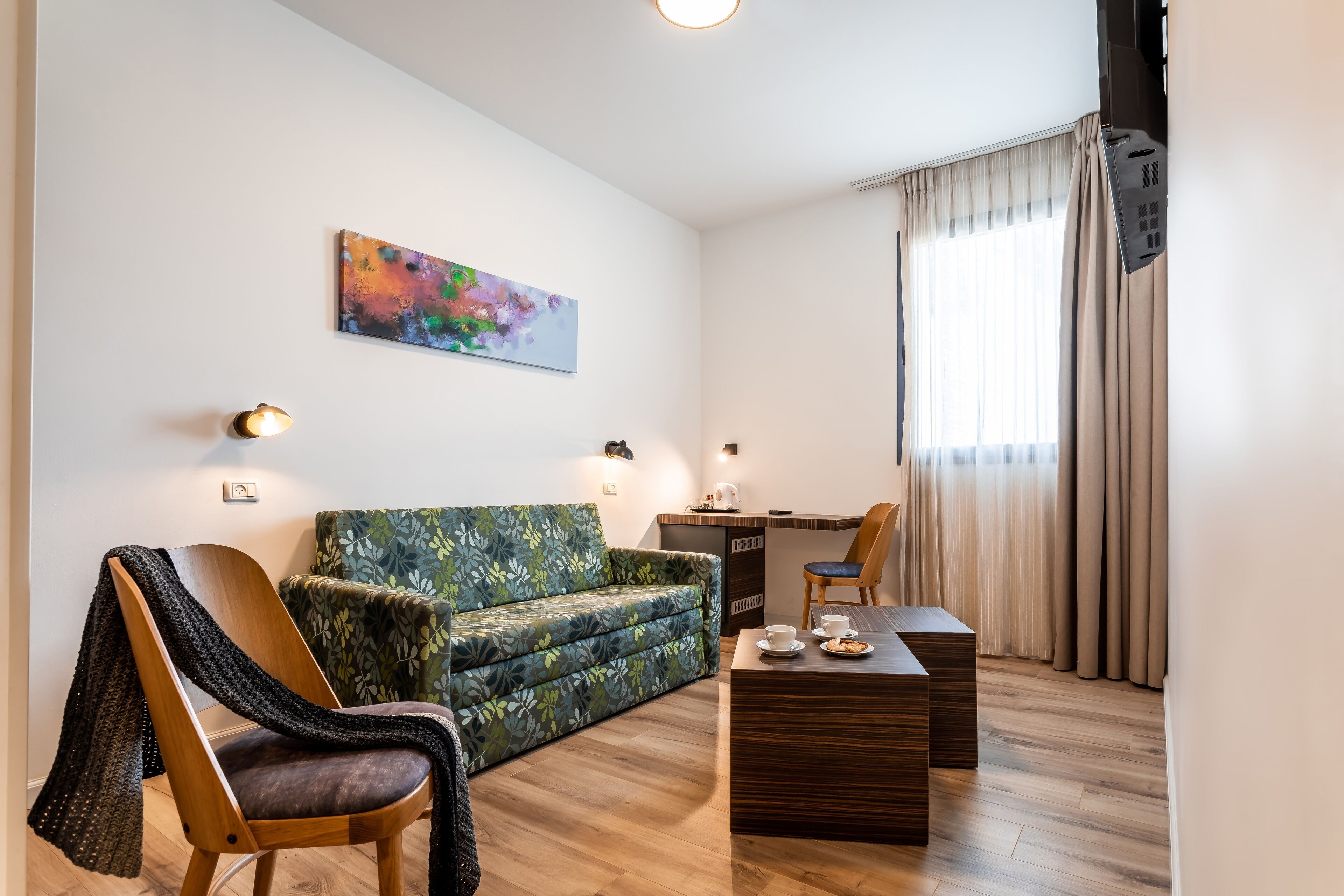 Un salon moderne comprenant un canapé, un fauteuil, une table basse et un bureau.